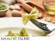 Поедание вкусной пасты песто с тарелки, крупным планом. Стоковое фото, фотограф Pixel_shot / Фотобанк Лори