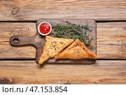 Доска с вкусной узбекской самсой и томатным соусом на деревянном фоне. Стоковое фото, фотограф Pixel_shot / Фотобанк Лори