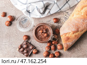 Баночка с вкусной шоколадной пастой и фундуком на сером фоне. Стоковое фото, фотограф Pixel_shot / Фотобанк Лори