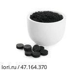 Чаша с зубным порошком с активированным углем и таблетками на белом фоне. Стоковое фото, фотограф Pixel_shot / Фотобанк Лори