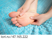 Woman giving herself foot massage, corns and calluses on feet, dry skin on legs. Стоковое фото, фотограф Станислав Тарко / Фотобанк Лори