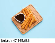 Доска с вкусными чуррос и соусом из расплавленного шоколада на цветном фоне. Стоковое фото, фотограф Pixel_shot / Фотобанк Лори