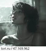 Portrait of a young woman with short wavy hair, standing in water. She appears thoughtful, her face turned upwards as if she is catching the light or steam. Drops of water glisten on her skin, creating an effect of wetness and intimacy of the scene. The photograph is made in soft, muted tones, close to black and white or sepia. The atmosphere of the picture is mysterious, with an emphasis on natural beauty, the play of light and shadow. The water and light steam give the scene a sense of coziness and calm, perhaps creating associations with a bath or a hot spring. Стоковое AI-изображение, AI-художник Анна Кривицкая / Фотобанк Лори