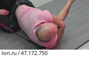 Bald man performing suspension training exercises for rotator cuff. Стоковое видео, видеограф Юрий Поздников / Фотобанк Лори