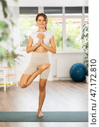 Experienced girl fitness club teacher performs ardha padma vrikshasana. Стоковое фото, фотограф Яков Филимонов / Фотобанк Лори