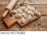 Доска с сырыми клецками и специями на деревянном фоне. Стоковое фото, фотограф Pixel_shot / Фотобанк Лори