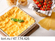 Форма для выпечки с подготовленной лазаньей на белом столе. Стоковое фото, фотограф Pixel_shot / Фотобанк Лори