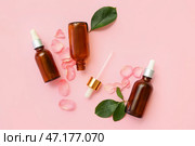 Бутылки косметического масла с экстрактом розы, лепестками и листьями на розовом фоне. Стоковое фото, фотограф Pixel_shot / Фотобанк Лори