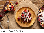 Тарелка с кусочком вкусного вишневого пирога на деревянном фоне. Стоковое фото, фотограф Pixel_shot / Фотобанк Лори