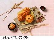 Тарелка с вкусными булочками в форме тыквы на розовом плиточном фоне. Стоковое фото, фотограф Pixel_shot / Фотобанк Лори