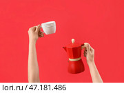 Женские руки, держащие чашку и кофеварку с гейзерным кипятильником на красном фоне. Стоковое фото, фотограф Pixel_shot / Фотобанк Лори