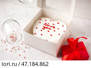 Коробка с тортом бенто в форме сердца, стаканами и подарком на белом столе. Празднование Дня святого Валентина. Стоковое фото, фотограф Pixel_shot / Фотобанк Лори