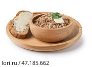Деревянная миска вкусной гречневой каши с маслом, хлебом и укропом на белом фоне. Стоковое фото, фотограф Pixel_shot / Фотобанк Лори