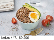 Тарелка вкусной гречневой каши с яйцом всмятку и свежими овощами на сером столе. Стоковое фото, фотограф Pixel_shot / Фотобанк Лори