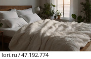The interior of a modern house. A minimalistic cozy beige bedroom interior with a plaid, pillows, a headboard, linen linens and a bedside table. Стоковое AI-изображение, AI-художник Photojuli / Фотобанк Лори
