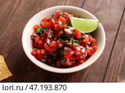 Чаша вкусной сальсы Пико де Галло на столе. Стоковое фото, фотограф Pixel_shot / Фотобанк Лори