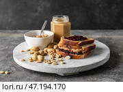 Доска с вкусным бутербродом с арахисом на фоне гранж. Стоковое фото, фотограф Pixel_shot / Фотобанк Лори