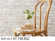 Подарочные коробки и красивые цветы жасмина на стуле у кирпичной стены. Стоковое фото, фотограф Pixel_shot / Фотобанк Лори