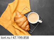 Чашка свежесваренного кофе и круассан на темном фоне. Стоковое фото, фотограф Pixel_shot / Фотобанк Лори