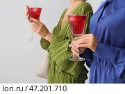Модницы держат бокалы с вкусным коктейлем на светлом фоне, крупным планом. Стоковое фото, фотограф Pixel_shot / Фотобанк Лори