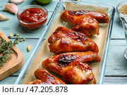 Форма для запекания с жареными куриными крылышками и соусом на цветном деревянном фоне. Стоковое фото, фотограф Pixel_shot / Фотобанк Лори