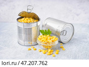 Жестяные банки, миска с кукурузными зернами и листьями петрушки на сером столе. Стоковое фото, фотограф Pixel_shot / Фотобанк Лори