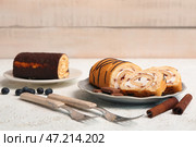 Тарелки с вкусным бисквитом, корицей, кофейными зернами и вилками на светлом гранж-фоне. Стоковое фото, фотограф Pixel_shot / Фотобанк Лори