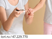 Мать проверяет уровень сахара в крови дочери-диабетика на цветном фоне. Стоковое фото, фотограф Pixel_shot / Фотобанк Лори