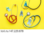 Синие ленты и стетоскопы на цветном фоне. Концепция осведомленности рака простаты. Стоковое фото, фотограф Pixel_shot / Фотобанк Лори