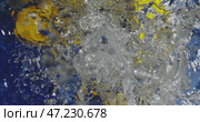 Throwing lemons into water on a blue background. Splashes spilling in different directions. Slow motion splashes. Стоковое видео, видеограф Владимир Ковальчук / Фотобанк Лори