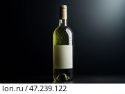A mockup of a misted-up bottle of white wine with an empty label on a dark background. Стоковое AI-изображение, AI-художник Алексей Кузнецов / Фотобанк Лори