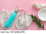 Эко-посуда, авоська, бутылка и ветка растения на розовом фоне. Стоковое фото, фотограф Pixel_shot / Фотобанк Лори