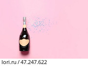 Бутылка шампанского и блестит на цветном фоне. Встреча Нового года. Стоковое фото, фотограф Pixel_shot / Фотобанк Лори