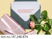 Открытка с текстом VIELEN DANK, конверт, роза и подарочные коробки на бежевом фоне. Стоковое фото, фотограф Pixel_shot / Фотобанк Лори