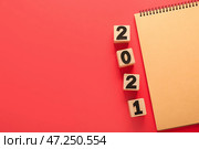 Блокнот и кубики с цифрой 2021 на цветном фоне. Стоковое фото, фотограф Pixel_shot / Фотобанк Лори