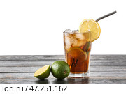 Стакан вкусного коктейля Cuba Libre на столе на белом фоне. Стоковое фото, фотограф Pixel_shot / Фотобанк Лори