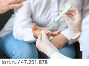 Врач берет образец крови у пожилой женщины с диабетом у себя дома. Стоковое фото, фотограф Pixel_shot / Фотобанк Лори