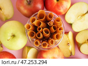 Свежие яблоки и стакан вкусных фруктовых пастилок на розовом фоне, крупным планом. Стоковое фото, фотограф Pixel_shot / Фотобанк Лори