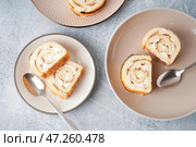 Тарелки с кусочками вкусного бисквита и ложками на светлом столе. Стоковое фото, фотограф Pixel_shot / Фотобанк Лори