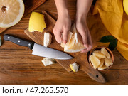 Женские руки с кусочком свежего помело и ножом на деревянном фоне. Стоковое фото, фотограф Pixel_shot / Фотобанк Лори