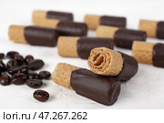 Вкусные вафельные трубочки и кофейные зерна на светлом столе, крупным планом. Стоковое фото, фотограф Pixel_shot / Фотобанк Лори