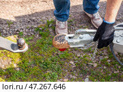 A man attaches a car trailer to a car by connecting the trailer's drawbar to the car's towbar. Стоковое фото, фотограф Коханова Наталья / Фотобанк Лори
