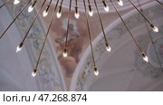 Modern chandelier illuminating ancient frescoes in a baroque church. Стоковое видео, видеограф Mikhail Davidovich / Фотобанк Лори