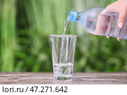 Налив воды в стакан на столе на открытом воздухе. Стоковое фото, фотограф Pixel_shot / Фотобанк Лори