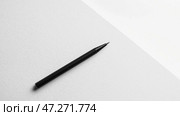 Black pen resting on a clean, white surface among notes and stationery in a workspace setting. Черная ручка лежит на безупречно белой поверхности, создавая впечатление рабочего пространства, готового для письма или мозгового штурма идей. Простота подчеркивает продуктивность и сосредоточенность. Стоковое AI-изображение, AI-художник Katsiaryna Repich / Фотобанк Лори