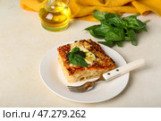 Тарелка вкусного итальянского пирога с моцареллой и соусом песто на светлом фоне. Стоковое фото, фотограф Pixel_shot / Фотобанк Лори