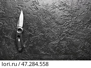 Складной перочинный нож с прорезиненной рукоятью на черном фактурном фоне. Стоковое фото, фотограф Pixel_shot / Фотобанк Лори