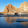 Spring morning on Baikal Lake. View of the famous Shamanka rock - a natural landmark of Olkhon Island in the rays of the rising sun. The bay is covered with a thin crust of blue ice. Scenic spring landscape. Стоковое фото, фотограф Виктория Катьянова / Фотобанк Лори