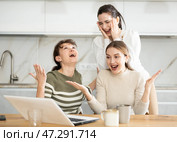 Three happy middle-aged woman expressing joy for winning in the kitchen. Стоковое фото, фотограф Яков Филимонов / Фотобанк Лори