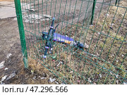 Брошенный электросамокат, на котором врезались в сварной забор из прутьев и повредили его. Редакционное фото, фотограф Александр Замараев / Фотобанк Лори